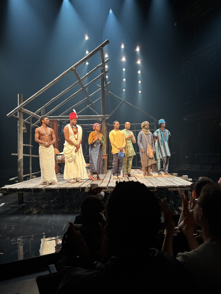 seven actors stand on stage to take a bow