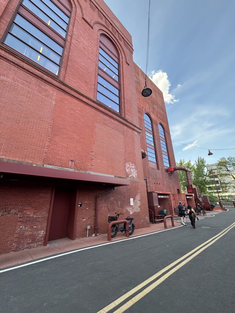 An exterior shot of a tall red-brick building taken from the street-level.