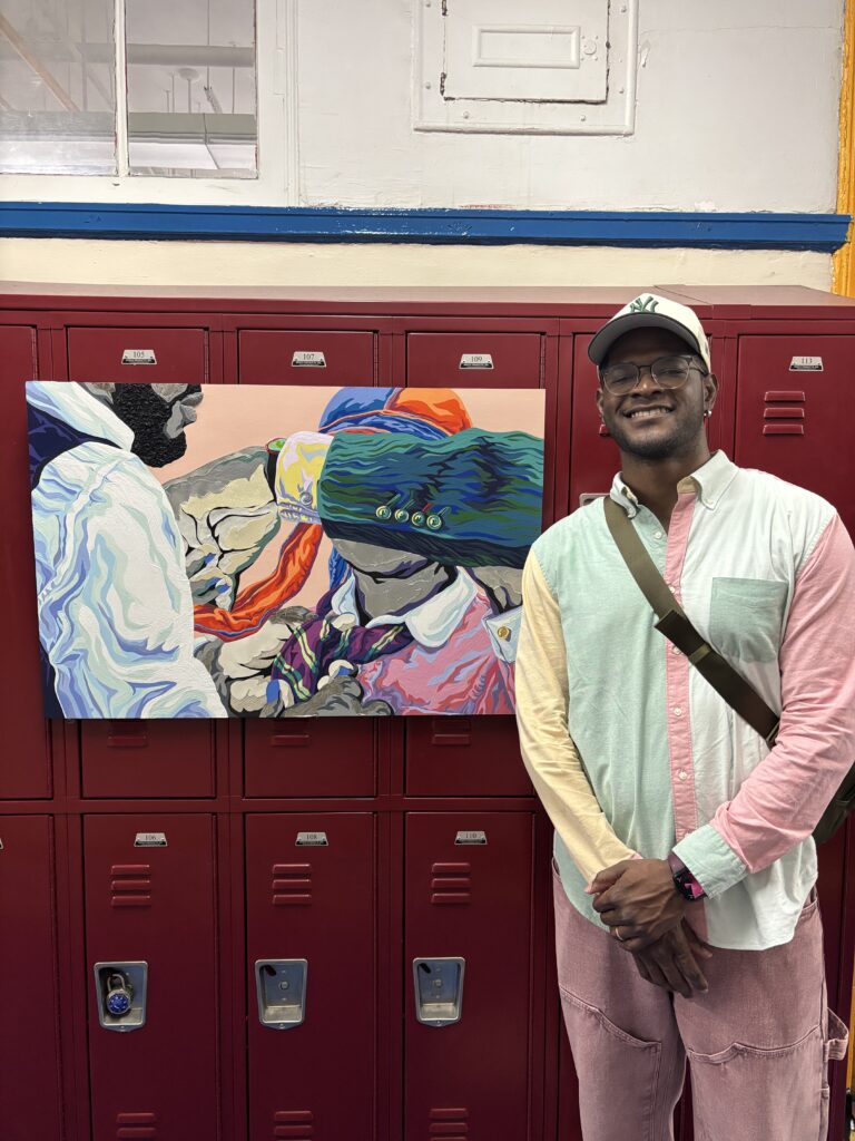 Artist stands next to artwork