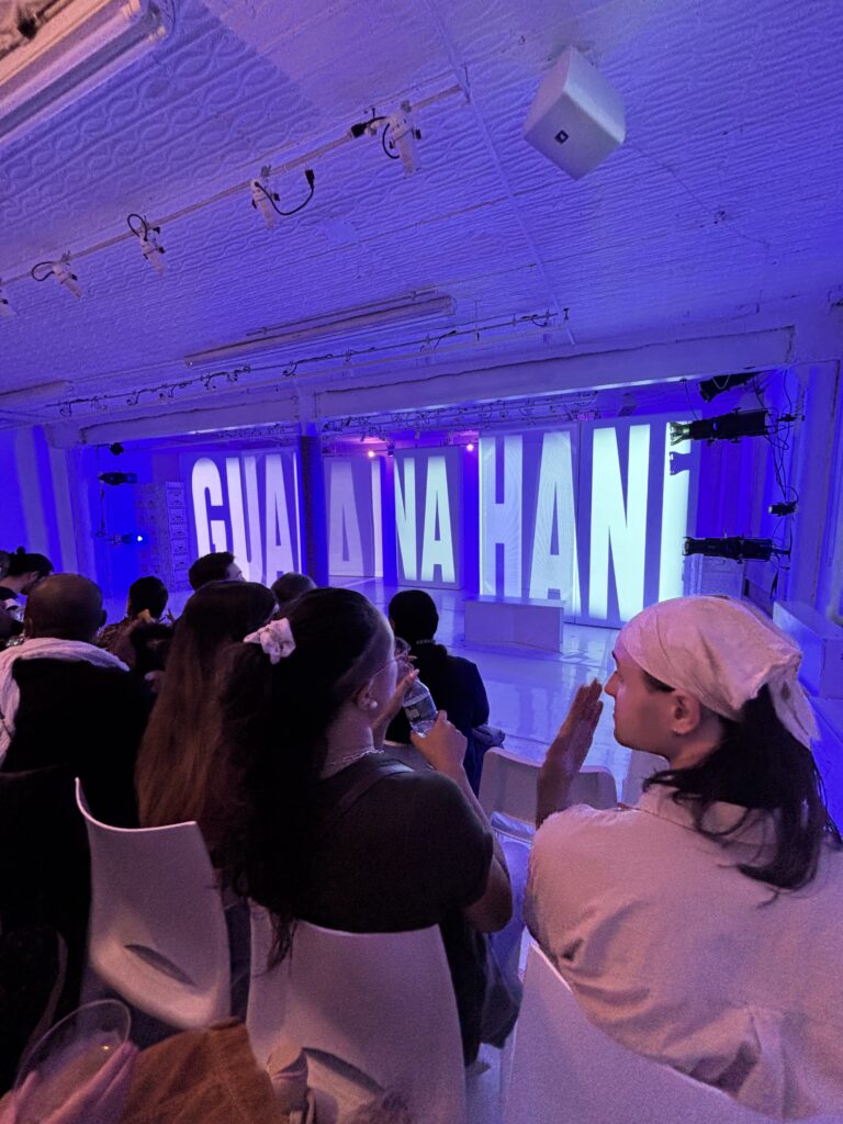 the stage with the title of the show projected
