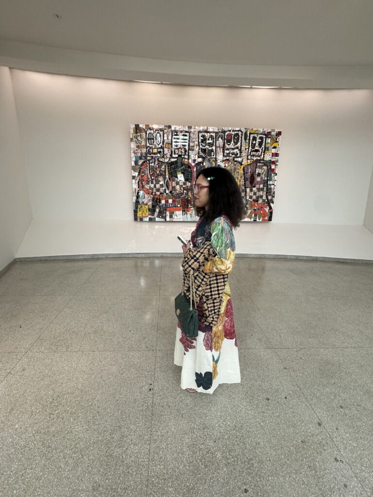 a woman stands in front of artwork