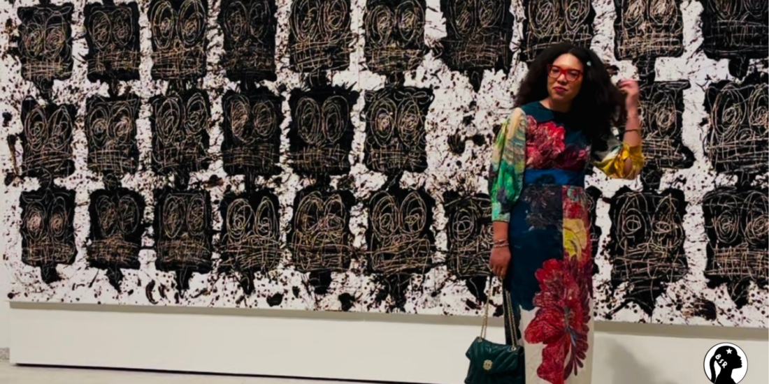 woman stands in front of artwork