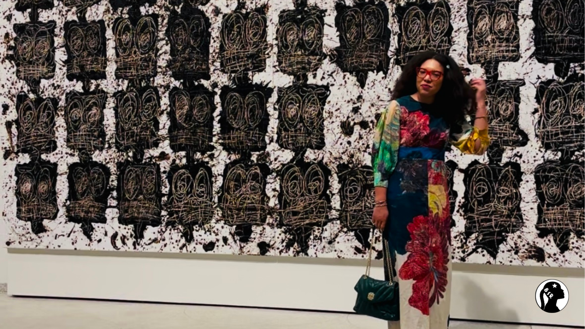 woman stands in front of artwork