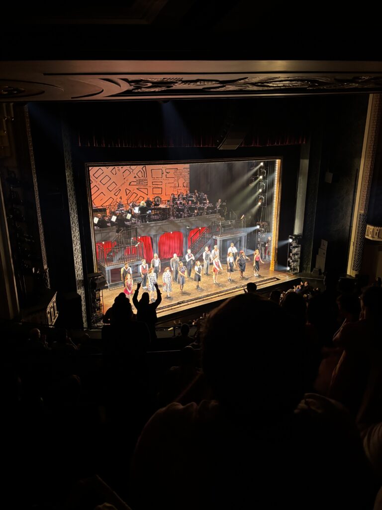 the cast takes a bow, as shown from the balcony