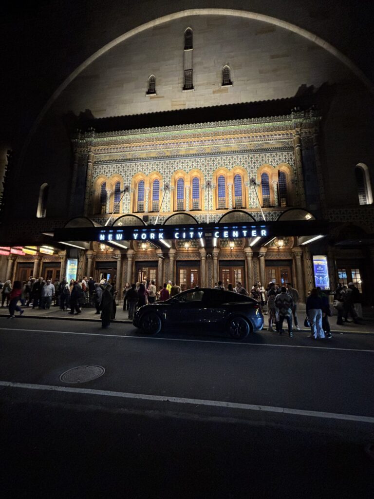 an exterior view of City Center at night from across the street
