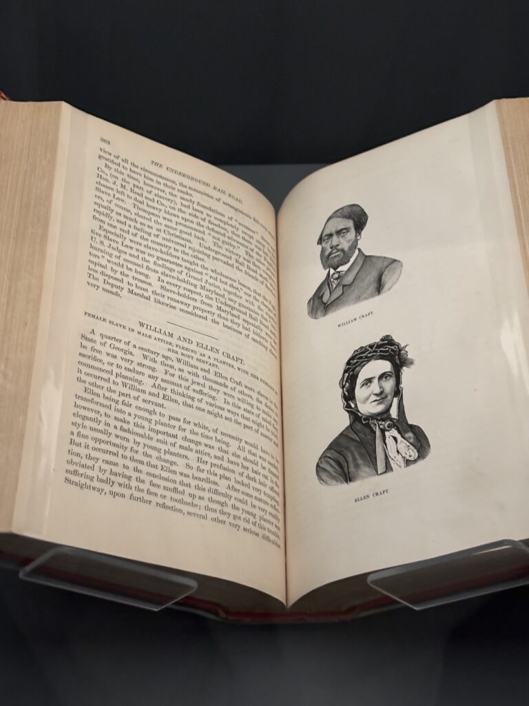a book is open behind glass in a museum