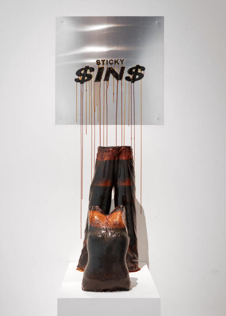 a shirt and pants made from sugar are beneath a sign that reads "sticky sins" but each letter S is replaced by a dollar sign $